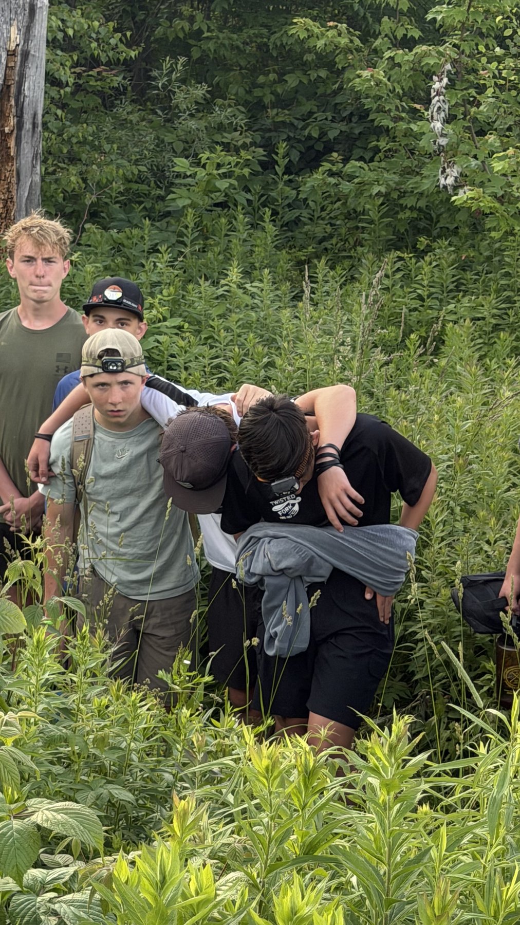 Teammates supporting an exhausted athlete in the field